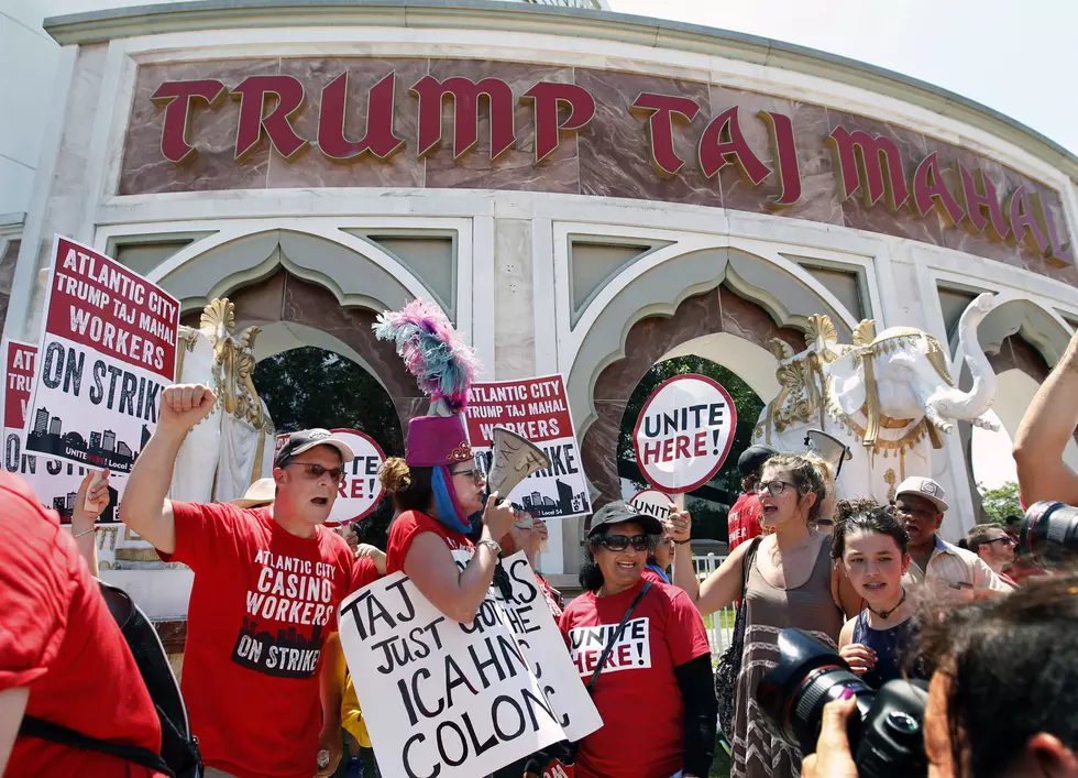Striking workers shout and hold signs as they picket outside the Trump Taj Mahal