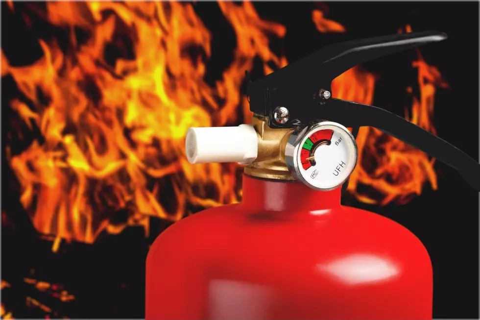 Red fire extinguisher and flames, close-up view